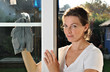 Junge Frau putzt Fenster