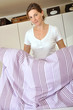 Junge Frau macht Bett