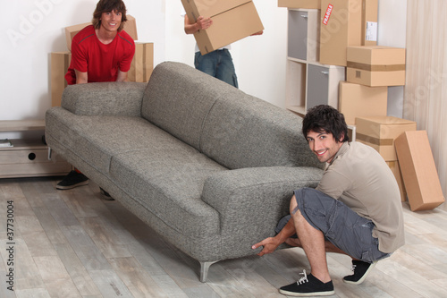 Photo: picture of friends moving a couch picture of friends moving a couch