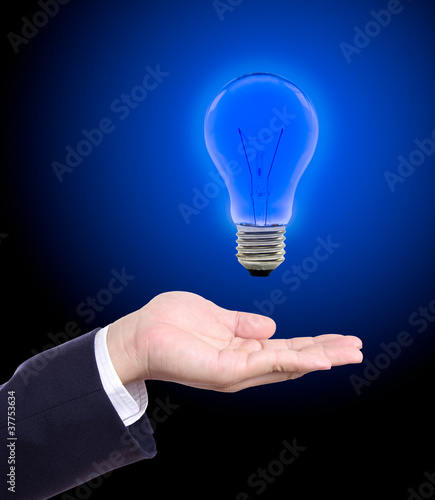 Photo: blue light bulb on hand blue light bulb on hand