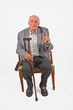elderly man sitting in his armchair with walking stick elderly man sitting in his armchair with walking stick