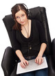 Beautiful young woman smiles while sitting at a laptop computer