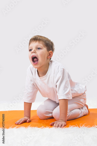 Photo: Children's yoga. The little boy does exercise. Children's yoga. The little boy does exercise.