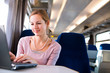 Young woman using her laptop computer while on the train