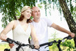 Photo: Young couple on the bikes in the park Young couple on the bikes in the park