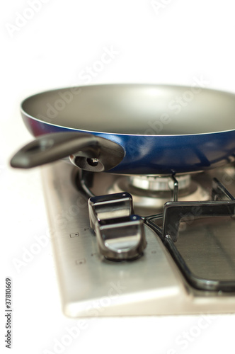 Photo: Frying pan on a stove against white. Frying pan on a stove against white.