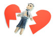 Voodoo doll boy on the broken heart isolated on white