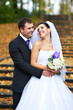 Joyful bride and groom in yellow autumn park