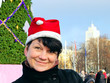 happy woman in cap Santa Claus near  New Year's fur-tree