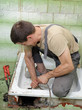 Photo: Plumber cleaning drain with cable Plumber cleaning drain with cable