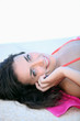 Smiling woman by a pool with a cellphone