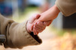 Senior and young holding hands