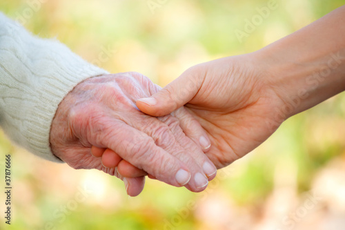 Photo: Senior and young holding hands Senior and young holding hands