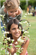 Little girls observing flowers through magnifying glass