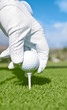 Golfer setting up golf ball on tee
