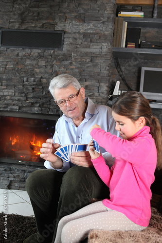 Photo: Little girl playing card game with granddad Little girl playing card game with granddad