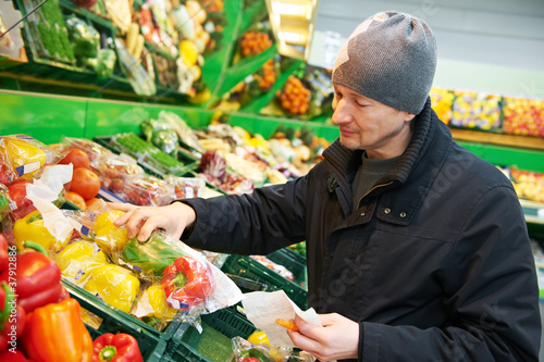 Photo: woman choosing vegetables in supermarket store woman choosing vegetables in supermarket store