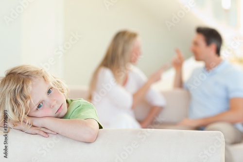 Photo: Sad boy with arguing parents behind him Sad boy with arguing parents behind him