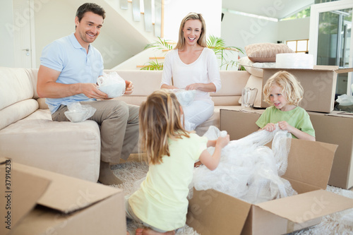 Photo: Family unpacking cardboard box in the living room Family unpacking cardboard box in the living room