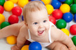 Portrait of a adorable infant sitting among colorful balls