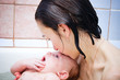 Photo: Mother kisses baby in a bathroom Mother kisses baby in a bathroom