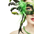 The beautiful young woman in a green mysterious venetian mask