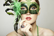 The beautiful young woman in a green mysterious venetian mask The beautiful young woman in a green mysterious venetian mask