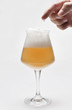 birra con schiuma e mano