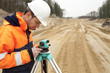 Road construction, land surveyor looking at equipment