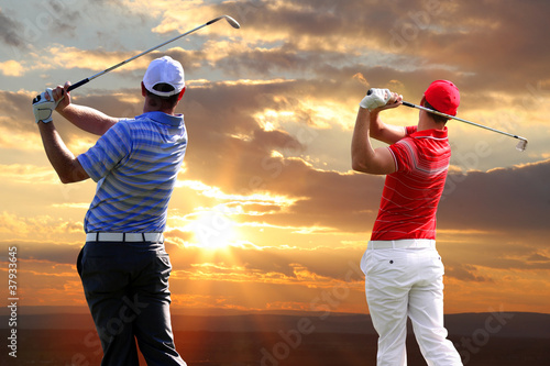 Foto: Men playing golf against sunset Men playing golf against sunset