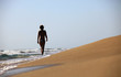 Beautiful young woman walking alone the beach