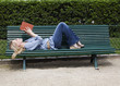 young woman reading a book on a bench