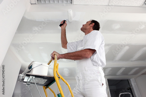 Foto: Tradesman painting a ceiling Tradesman painting a ceiling
