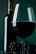 A glass full of wine and bottle