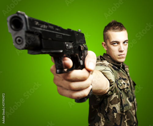 Photo: young soldier aiming with a gun young soldier aiming with a gun