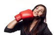 Pretty businesswoman hitting herself with boxing gloves