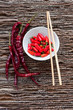 Bowl of chilli peppers with chopsticks