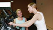 Fitness trainer with woman in gym