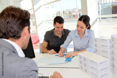 Foto: Couple discutant avec un agent immobilier Couple discutant avec un agent immobilier