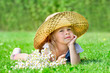 The little girl in hat lying on the lawn