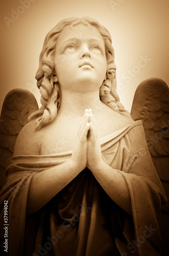 Photo: Beautiful vintage image of a praying angel in sepia shades Beautiful vintage image of a praying angel in sepia shades