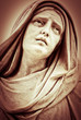 Vintage sepia image of a suffering religious woman statue