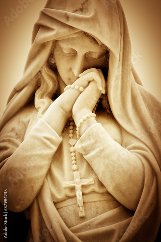 Photo: Vintage sepia image of a religious woman with a crucifix Vintage sepia image of a religious woman with a crucifix