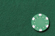 green poker chip on a table with taxt space