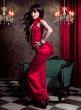 schöne Frau mit rotem Abendkleid in antikem Raum / lady in red