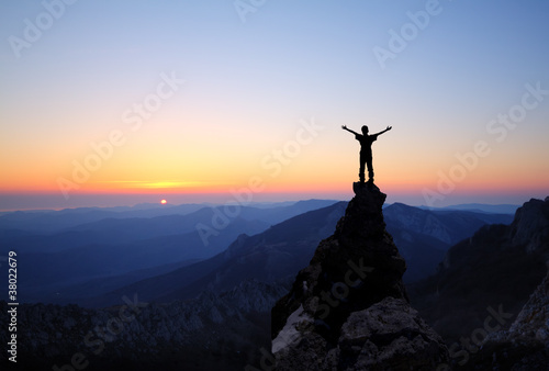 Photo: Silhouette of men on top of the mountain Silhouette of men on top of the mountain