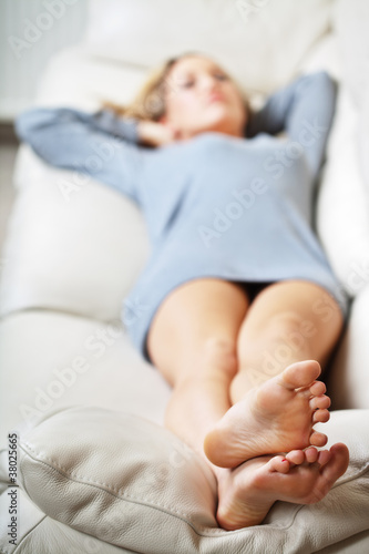 Photo: Young woman lying on sofa, focus on her feet Young woman lying on sofa, focus on her feet