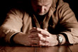 Clasped hands on troubled man