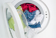 washing machine door full of colored clothes