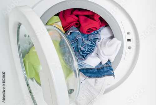 Photo: washing machine door full of colored clothes washing machine door full of colored clothes